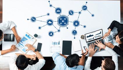 A diverse group of professionals engaged in a strategic business meeting, utilizing digital tools and data visualization to enhance collaboration and decision-making. Amity