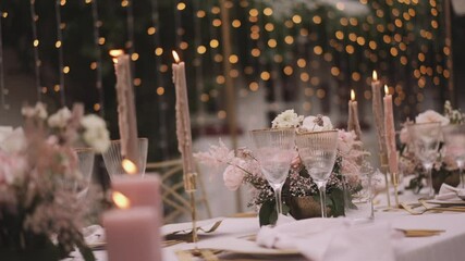 Wedding table in pastel colors with elegant decorations and yellow string lights
