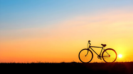Obraz premium Silhouette Of A Bicycle Against A Vivid Orange Sunset Sky Over A Field