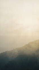 Fototapeta premium Ethereal fog veiling mountains at dawn, serene beauty