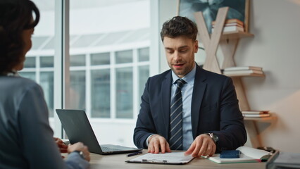 Manager explaining contract details to businesswoman at modern office closeup. 