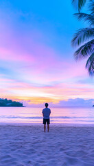 Man silhouetted against a vibrant sunset on a tropical beach