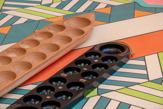 Discover the timeless appeal of Mancala with this detailed image featuring two distinct Mancala boards. 