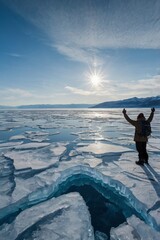 Person walking across a frozen lake surrounded by snowy mountains.