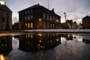 Reykjavik after a rain strom in the evening, a building is reflected in a big puddle 