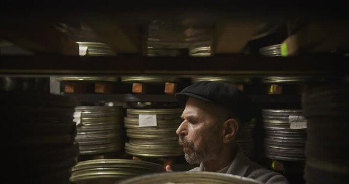 Elderly Archivist Searching for a Vintage Film Reel in a Historical Archive