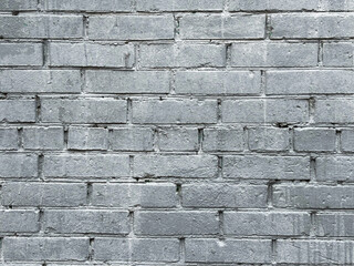 Real old grey brick wall with small paint stains, close-up. Background for banner, poster, designs.