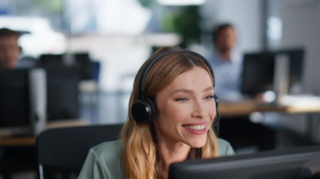 Help desk specialist talking on headset working computer at office closeup.