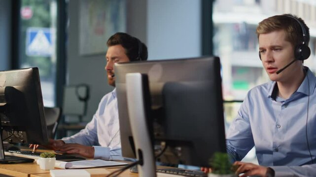 Contact center team working at computers talking headset in office space closeup