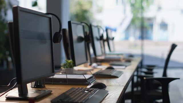 Empty office desks computers and headphones at workspace. Organized call center