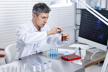 Scientist with test tubes working in laboratory