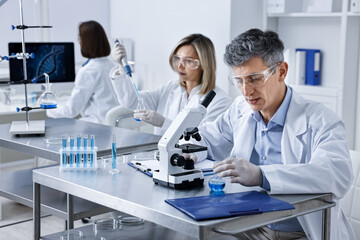 Scientists working with samples at table in laboratory