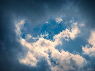 Blue sky framed by dramatic storm clouds. Heavenly background.