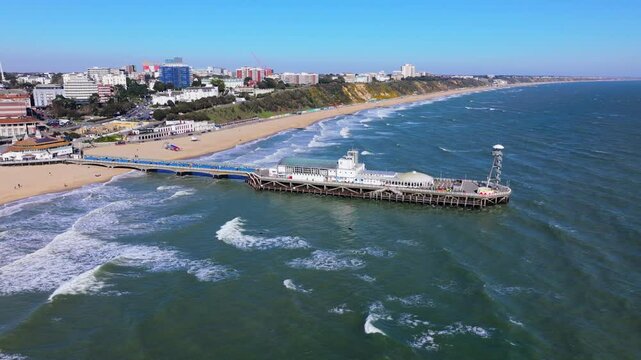 Aerial shot of Bournemouth pier and coastline with big waves in strong wind