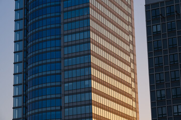 Obraz premium A skyscraper at sunset in the evening. Glass skyscraper close-up. 