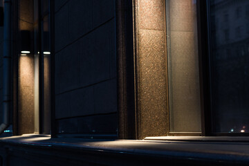 Illumination of the granite-marble facade of the old building late at night