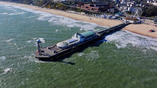 Aerial shot of Bournemouth Pier and coastline in strong winds, heavy seas and big waves