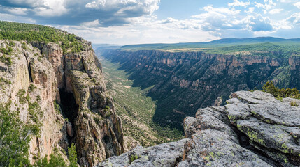 Expansive View of a Majestic Canyon with Lush Greenery and Dramatic Cloudy Sky in the Background
