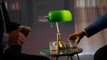 High class elite members of society clinking whiskey glasses for a toast, celebrating their new...