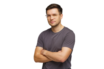 Young man stands confidently with arms crossed in casual attire in a studio setting, showcasing a relaxed demeanor