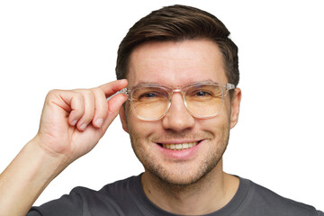 Young man adjusting clear glasses while smiling, showcasing friendly demeanor in casual attire