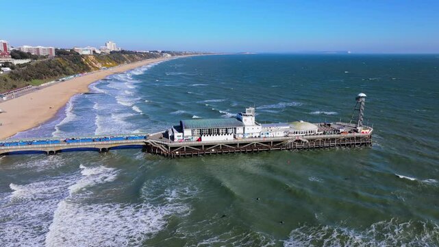 Aerial shot of Bournemouth Pier and coastline in strong winds, heavy seas and big waves