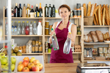 Female salesperson offers to buy a bottle of mineral water in the grocery supermarket