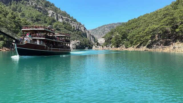 ANTALYA - TURKEY - 10 June 2024: Boat on the water of Manavgat river in Antalya (Manavgat) Turkey. Tourist travelling by boat to see Green Canyon, tourist attractions