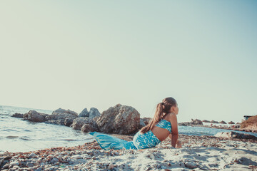 Young girl portrait in mermaid costume on the beach near sea