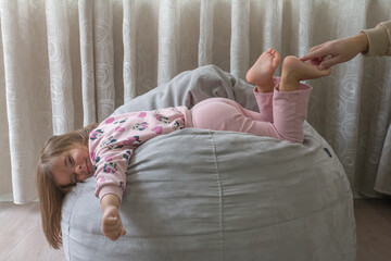 little girl trying not to laugh at her father's tickling of her leg,family and love concept