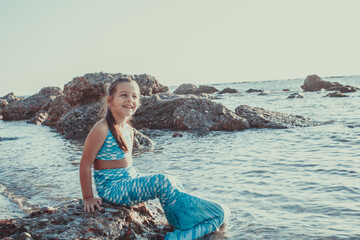 Young girl portrait in mermaid costume on the beach near sea