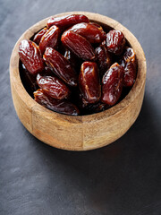 Dried Dates in Bowl on Dark Background, Healthy and Organic Middle Eastern Snack, Copy Space