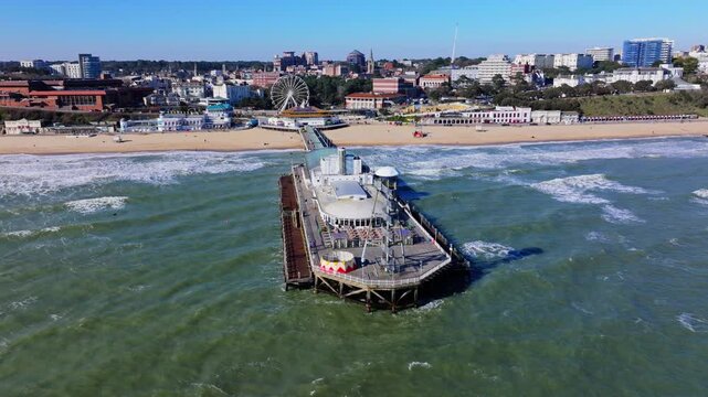 Aerial shot of Bournemouth Pier and coastline in strong winds, heavy seas and big waves