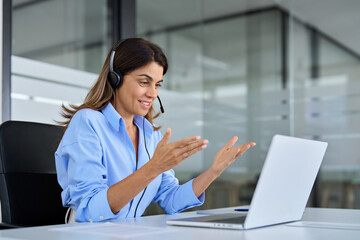 Busy mature business woman call center representative customer support agent helping client, smiling middle aged senior female operator wearing headset working using laptop computer in office.