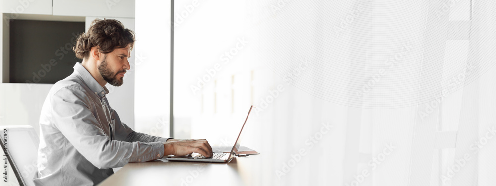 Poster side view of handsome mature businessman working at office, using laptop computer, sitting at desk, 