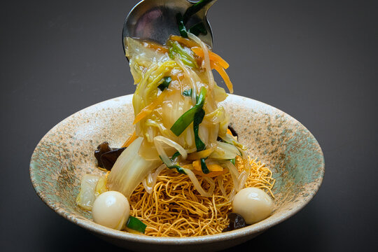 パリパリの食感がおいしい固焼きめんに、炒めた野菜を餡かけにして完成したあんかけ焼きそば