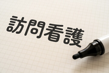 訪問看護と書かれたノートとマーカー