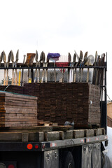 Work truck filled with wood fencing supplies and hand tools, post hole digger, shovel, rake, broom,...