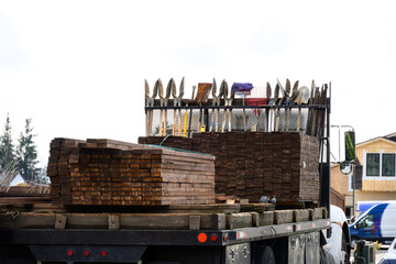 Work truck filled with wood fencing supplies and hand tools, post hole digger, shovel, rake, broom,...
