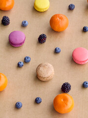 Colorful Macarons with Berries and Citrus on Plain Background