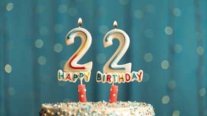 A Celebratory 22nd Birthday Cake With Lit Candles Against A Dreamy Teal Backdrop, Capturing The Joy And Excitement Of A Special Milestone