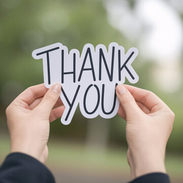 Illustration concept of Thank You sign held in two hands blurred background