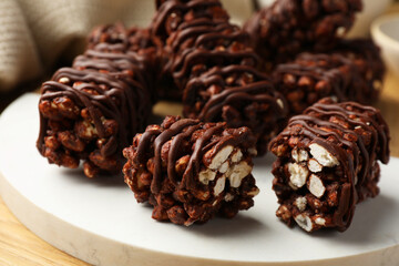 Delicious chocolate puffed rice bars on wooden table, closeup