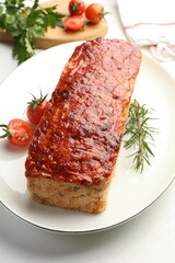 Delicious baked turkey meatloaf, rosemary, cherry tomatoes and parsley on white table, closeup
