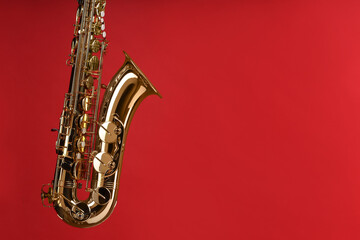 Jazz. One beautiful saxophone on red background, space for text