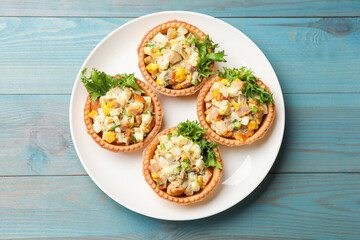Tartlets with delicious filling on blue wooden table, top view