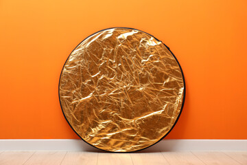 One light reflector near orange wall indoors. Photo studio equipment