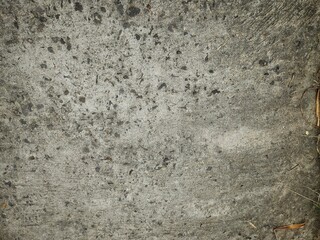 Rough concrete surface with small dark spots and natural imperfections