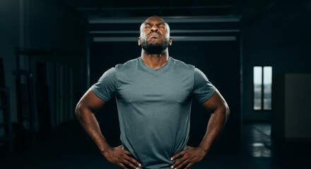 African adult male standing with eyes closed in dark room