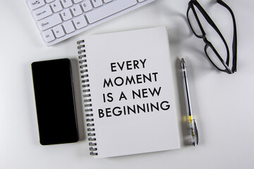 â€œEvery moment is a new beginningâ€ text on notebook with white background.